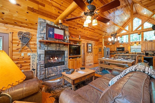 244 Hiddenwater Rd, Broken Bow, OK 74728 - living area featuring a stone fireplace, a ceiling fan, high vaulted ceiling, wooden walls, and a wood ceiling with exposed beams