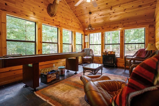 244 Hiddenwater Rd, Broken Bow, OK 74728 - living area featuring plenty of natural light, lofted ceiling, stone tile floors, wood walls, and wooden ceiling