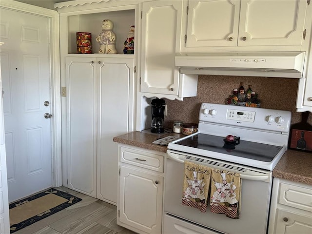 1901 N Oklahoma Ave, Shawnee, OK 74804 - kitchen featuring white electric stove, under cabinet range hood, white cabinets, and dark countertops