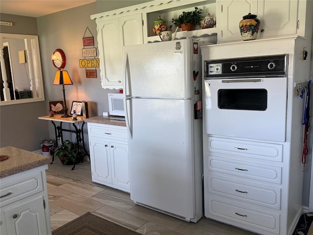 1901 N Oklahoma Ave, Shawnee, OK 74804 - kitchen featuring white appliances, white cabinets, and light countertops