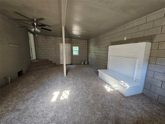 4001 SE 22nd St, Del City, OK 73115 - unfurnished living room featuring ceiling fan, concrete block wall, carpet, and a textured ceiling
