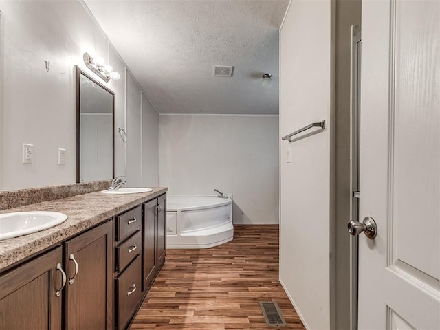 355370 E 970th Rd, Sparks, OK 74869 - full bath featuring a bath, wood finished floors, double vanity, and a textured ceiling