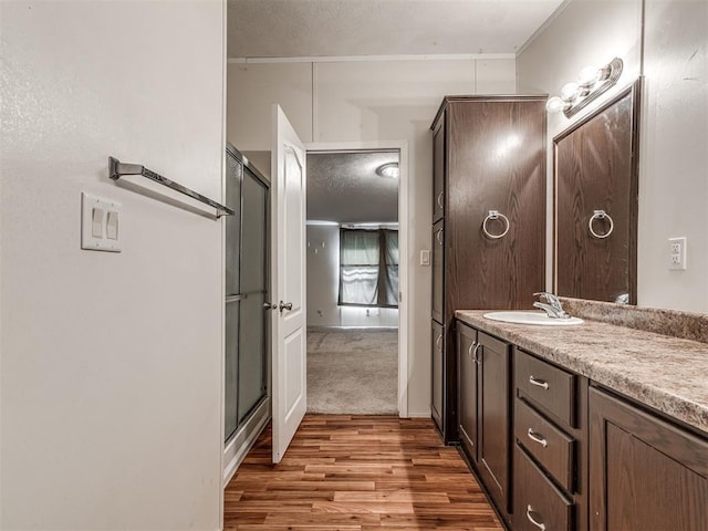 355370 E 970th Rd, Sparks, OK 74869 - bathroom with a textured ceiling, vanity, wood finished floors, and an enclosed shower