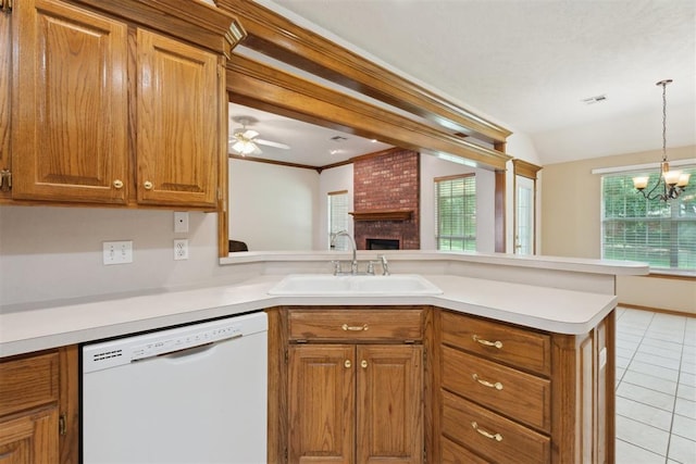 12417 Sussex Dr, Oklahoma City, OK 73130 - kitchen featuring white dishwasher, a peninsula, brown cabinetry, a brick fireplace, and light tile patterned flooring