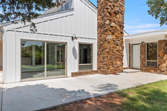 2104 Brookhaven Dr, Edmond, OK 73034 - back of property featuring stone siding, board and batten siding, and a patio