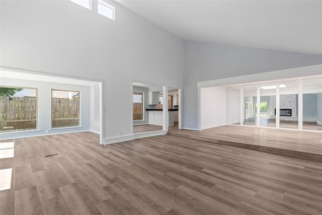 2104 Brookhaven Dr, Edmond, OK 73034 - unfurnished living room featuring high vaulted ceiling, wood finished floors, and a premium fireplace