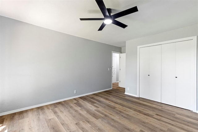 2104 Brookhaven Dr, Edmond, OK 73034 - unfurnished bedroom with wood finished floors, a closet, and a ceiling fan