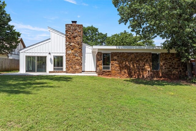 2104 Brookhaven Dr, Edmond, OK 73034 - back of property featuring board and batten siding, a chimney, and stone siding