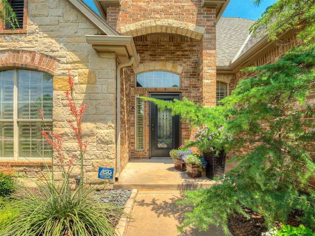16208 Windrush Pl, Edmond, OK 73013 - doorway to property featuring a shingled roof and stone siding