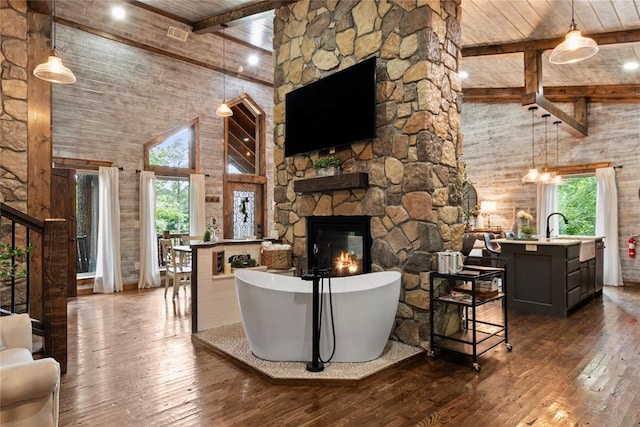 180 Black Jack Trl, Hochatown, OK 74728 - living area with high vaulted ceiling, dark wood-type flooring, healthy amount of natural light, a wood ceiling with exposed beams, and a stone fireplace