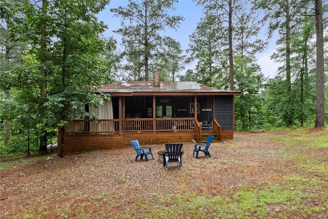 180 Black Jack Trl, Hochatown, OK 74728 - rear view of property featuring a deck, a chimney, and an outdoor fire pit