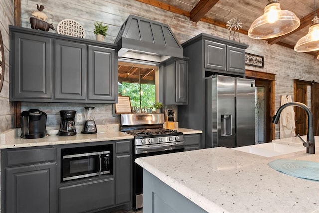 180 Black Jack Trl, Hochatown, OK 74728 - kitchen featuring appliances with stainless steel finishes, gray cabinetry, wall chimney range hood, a wooden ceiling with exposed beams, and hanging light fixtures