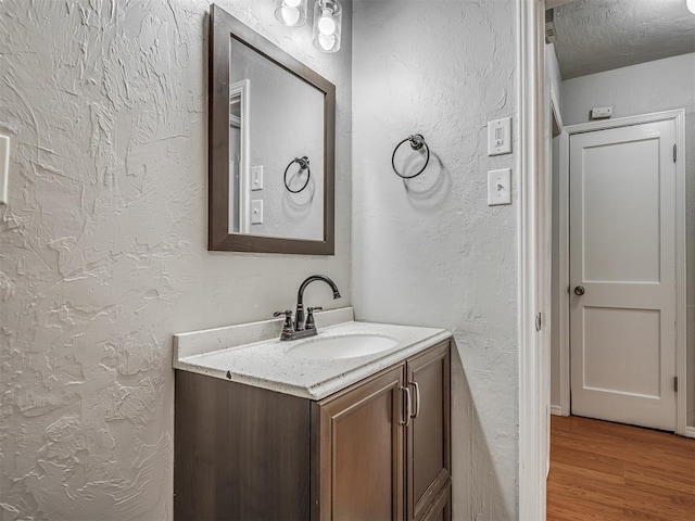 118 W Marshall Dr, Oklahoma City, OK 73110 - bathroom featuring a textured wall, vanity, and wood finished floors