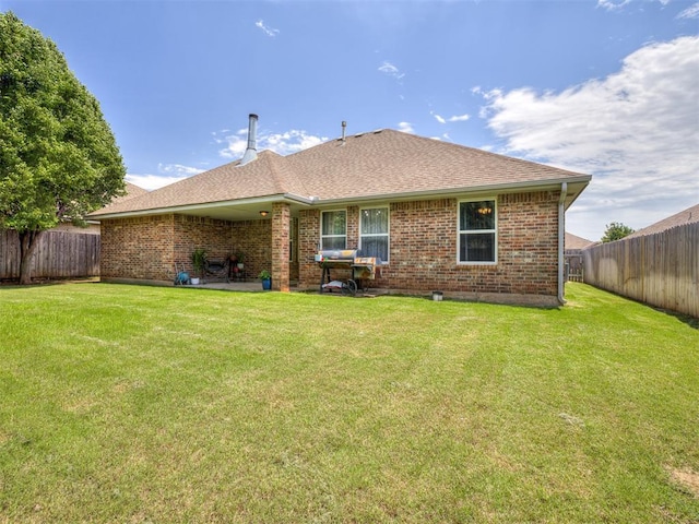 749 Dana Dr, Yukon, OK 73099 - rear view of house with a fenced backyard, brick siding, and a shingled roof