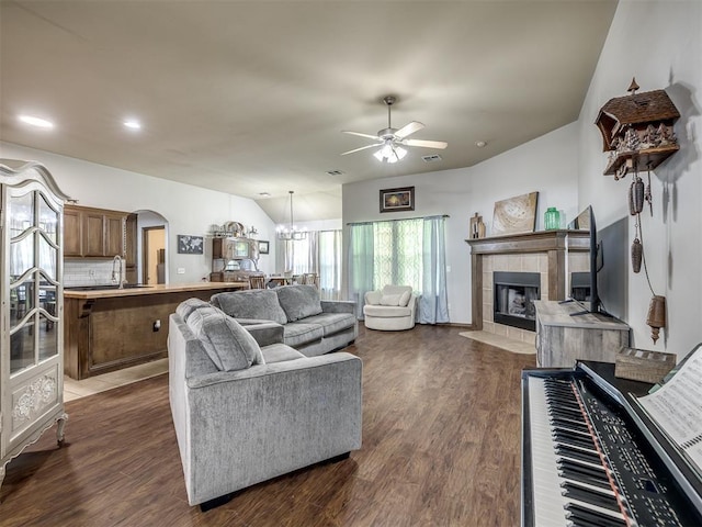 749 Dana Dr, Yukon, OK 73099 - living room with a ceiling fan, arched walkways, a tile fireplace, dark wood-style flooring, and a chandelier