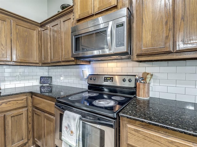 749 Dana Dr, Yukon, OK 73099 - kitchen with appliances with stainless steel finishes, decorative backsplash, brown cabinets, and dark stone countertops