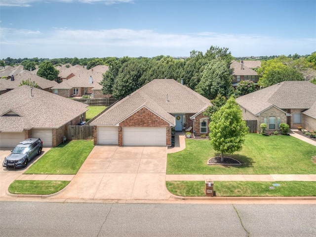 749 Dana Dr, Yukon, OK 73099 - view of front of house featuring an attached garage, driveway, brick siding, a shingled roof, and a residential view