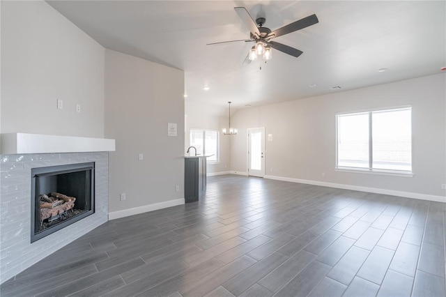 1224 Colonial Ave, Tuttle, OK 73089 - unfurnished living room featuring a ceiling fan, dark wood finished floors, a fireplace, and a chandelier