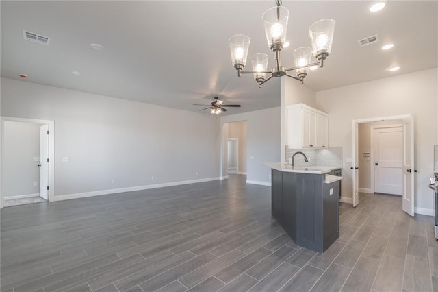 1224 Colonial Ave, Tuttle, OK 73089 - kitchen with ceiling fan, light countertops, white cabinets, a chandelier, and dark wood-type flooring