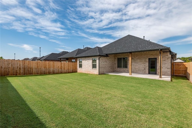 1224 Colonial Ave, Tuttle, OK 73089 - back of property featuring a patio area, a fenced backyard, roof with shingles, and brick siding