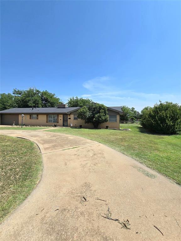 2015 Willard Dr, Altus, OK 73521 - ranch-style house featuring driveway, a garage, and a front yard