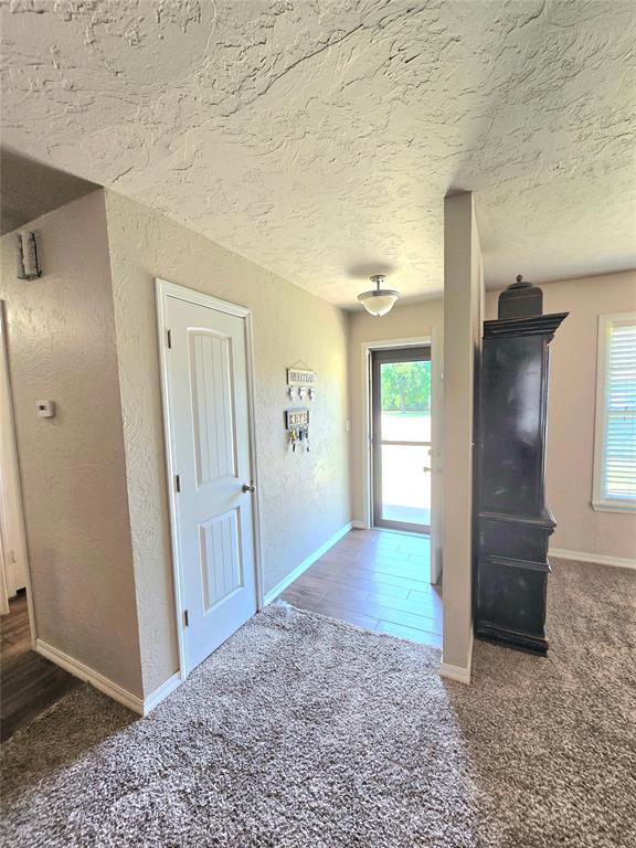 2015 Willard Dr, Altus, OK 73521 - hall with carpet floors, a textured ceiling, and a textured wall