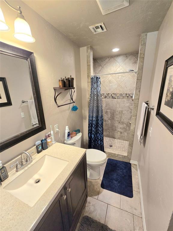 2015 Willard Dr, Altus, OK 73521 - full bathroom with a stall shower, vanity, and tile patterned floors