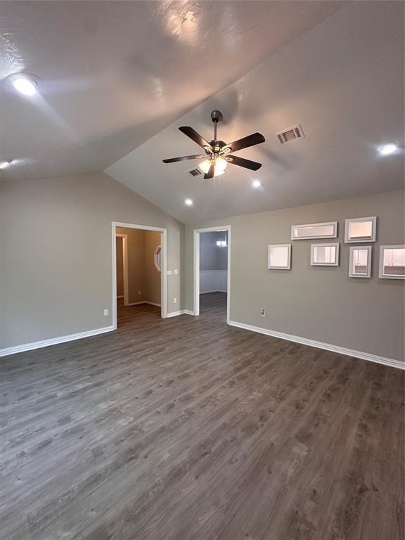 8317 NW 85th St, Oklahoma City, OK 73132 - spare room featuring ceiling fan, dark wood-style flooring, and vaulted ceiling