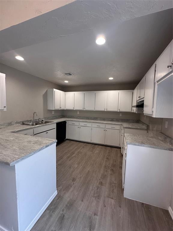 8317 NW 85th St, Oklahoma City, OK 73132 - kitchen featuring dishwasher, wood finished floors, a peninsula, white cabinets, and recessed lighting