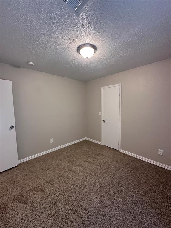 8317 NW 85th St, Oklahoma City, OK 73132 - unfurnished room with carpet floors, a textured ceiling, and a smoke detector