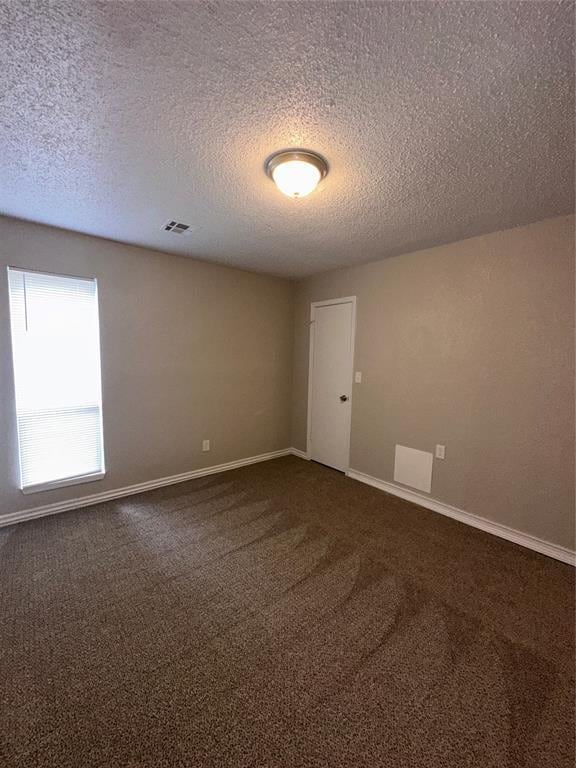 8317 NW 85th St, Oklahoma City, OK 73132 - unfurnished room with dark colored carpet and a textured ceiling