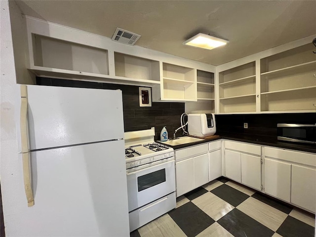 316 N University Blvd, Norman, OK 73069 - kitchen with white appliances, open shelves, dark countertops, tile patterned floors, and tasteful backsplash