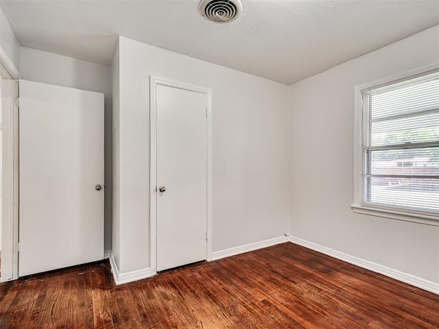 2713 S Glenn Ave, Del City, OK 73115 - unfurnished bedroom with wood finished floors and baseboards