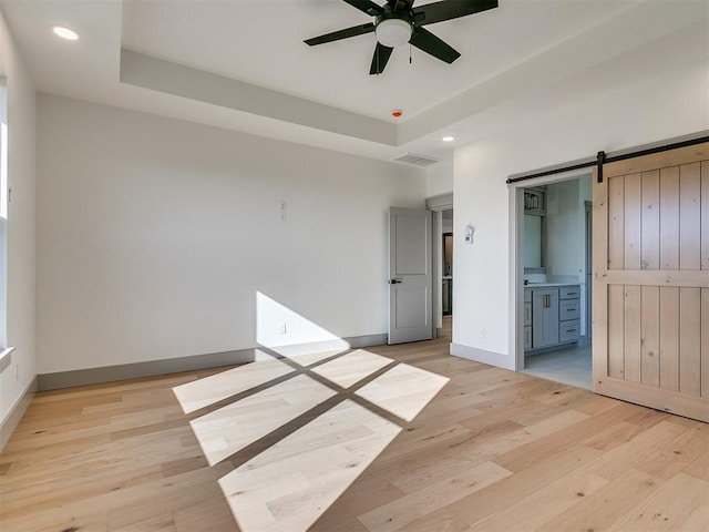 2741 Two Socks Run, Guthrie, OK 73044 - unfurnished bedroom featuring a barn door, recessed lighting, light wood-style floors, and ensuite bath