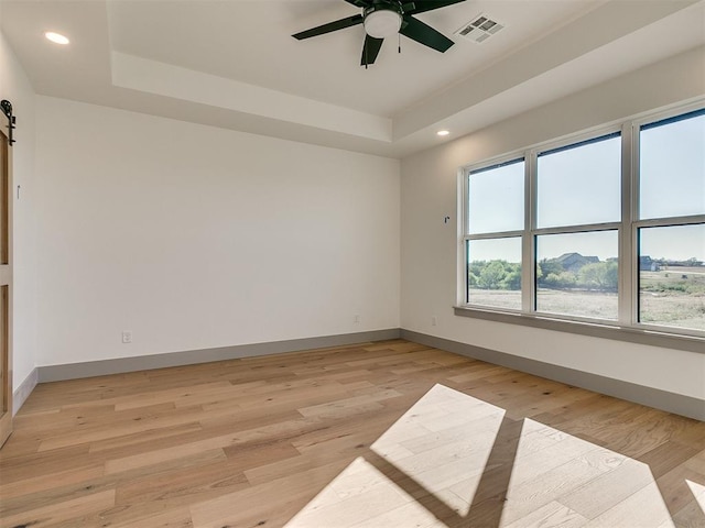 2741 Two Socks Run, Guthrie, OK 73044 - spare room with recessed lighting, a tray ceiling, ceiling fan, light wood finished floors, and a barn door