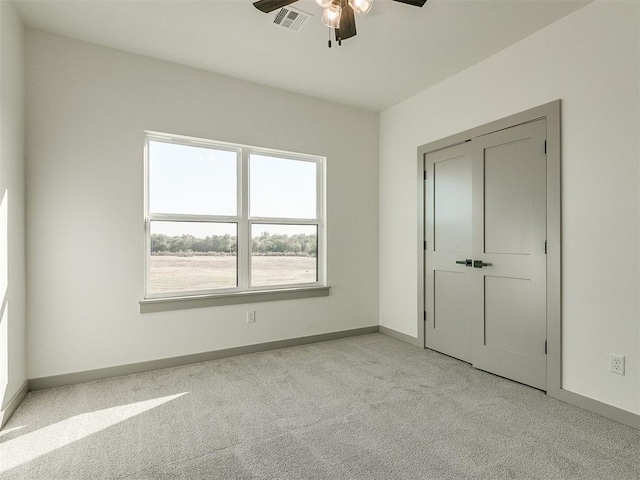 2741 Two Socks Run, Guthrie, OK 73044 - unfurnished bedroom with light colored carpet, multiple windows, and a ceiling fan