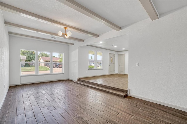 1608 Truman Dr, Altus, OK 73521 - unfurnished room with beam ceiling, wood finished floors, a chandelier, and a textured wall