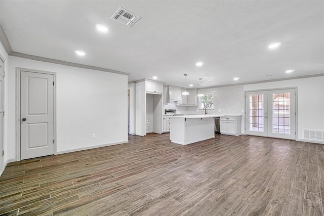 1608 Truman Dr, Altus, OK 73521 - unfurnished living room featuring wood finished floors, french doors, crown molding, and recessed lighting