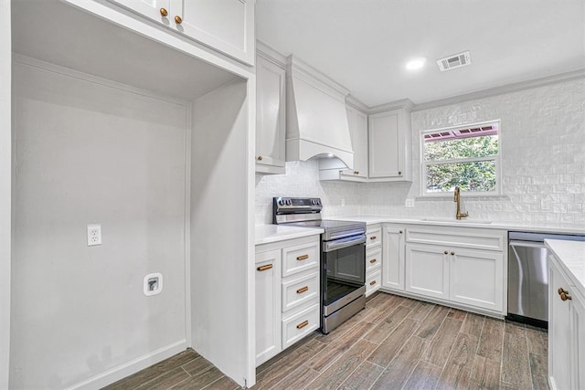 1608 Truman Dr, Altus, OK 73521 - kitchen with stainless steel appliances, dark wood-type flooring, light countertops, decorative backsplash, and white cabinets