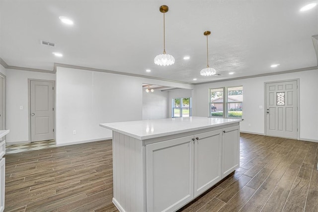 1608 Truman Dr, Altus, OK 73521 - kitchen with wood finished floors, recessed lighting, crown molding, light countertops, and a center island