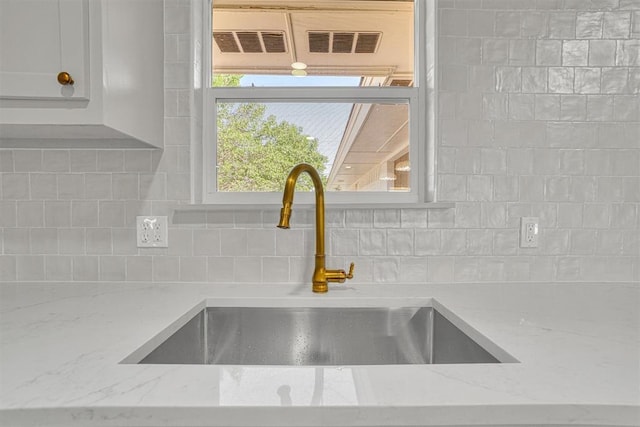 1608 Truman Dr, Altus, OK 73521 - kitchen view of tasteful backsplash, light stone countertops, and white cabinetry