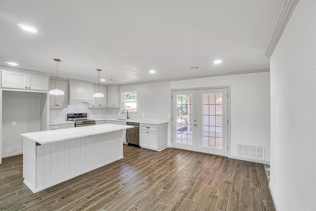 1608 Truman Dr, Altus, OK 73521 - kitchen featuring stainless steel appliances, dark wood-style flooring, tasteful backsplash, light countertops, and crown molding
