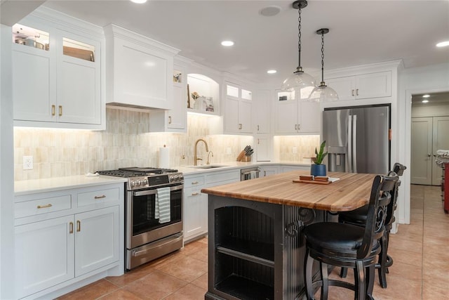 1503 Brighton Ave, Oklahoma City, OK 73120 - kitchen with stainless steel appliances, wood counters, light tile patterned flooring, white cabinets, and recessed lighting