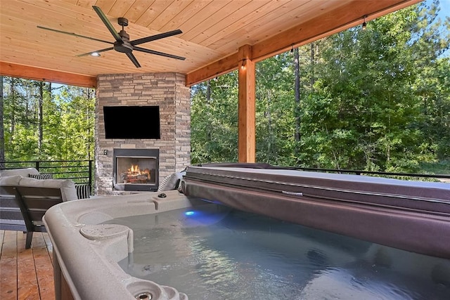 42 Hickory Ridge Rd, Broken Bow, OK 74728 - view of patio featuring an outdoor stone fireplace, a ceiling fan, and view of wooded area
