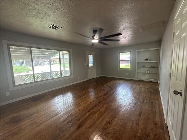 112 Burk Way, Del City, OK 73115 - empty room with a textured ceiling, dark wood-style floors, ceiling fan, and built in features