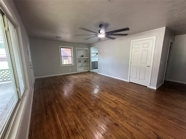 112 Burk Way, Del City, OK 73115 - unfurnished living room with ceiling fan, dark wood-style floors, a textured ceiling, built in features, and arched walkways