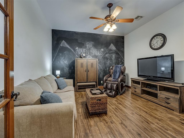 2108 Mulberry Creek Ave, Yukon, OK 73099 - living area featuring an accent wall, wood finished floors, and ceiling fan