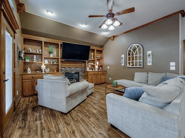2108 Mulberry Creek Ave, Yukon, OK 73099 - living room featuring lofted ceiling, a ceiling fan, wood finished floors, a stone fireplace, and crown molding