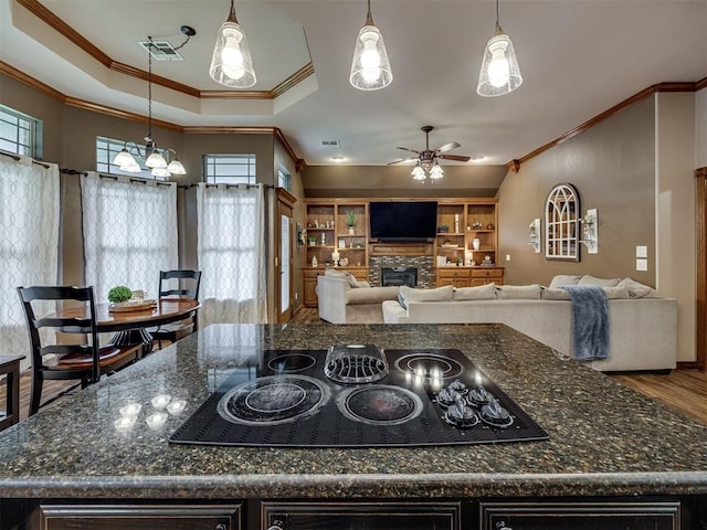2108 Mulberry Creek Ave, Yukon, OK 73099 - kitchen featuring crown molding, black electric stovetop, ceiling fan, a fireplace, and a kitchen island