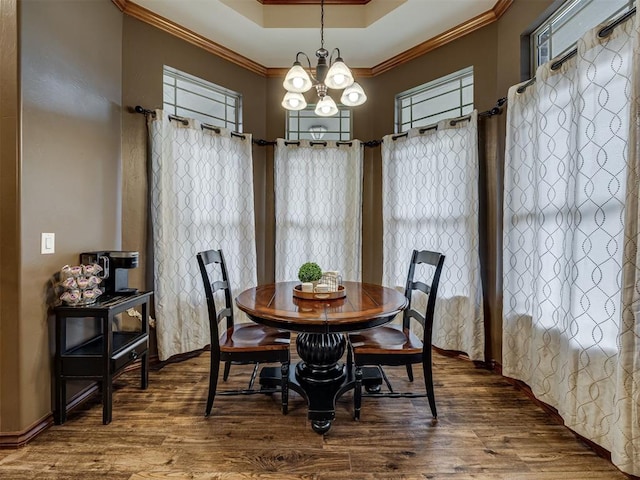 2108 Mulberry Creek Ave, Yukon, OK 73099 - dining space with crown molding, wood finished floors, healthy amount of natural light, a tray ceiling, and a chandelier